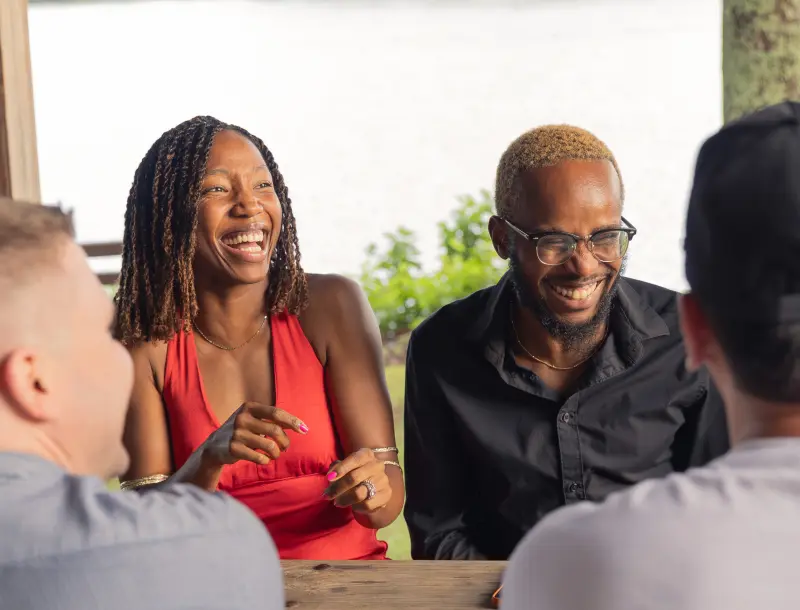 Friends talking and laughing around a table